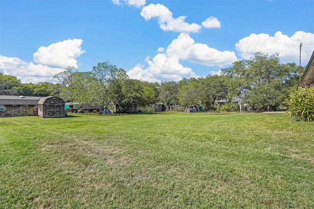 view of yard featuring a storage unit and a playground