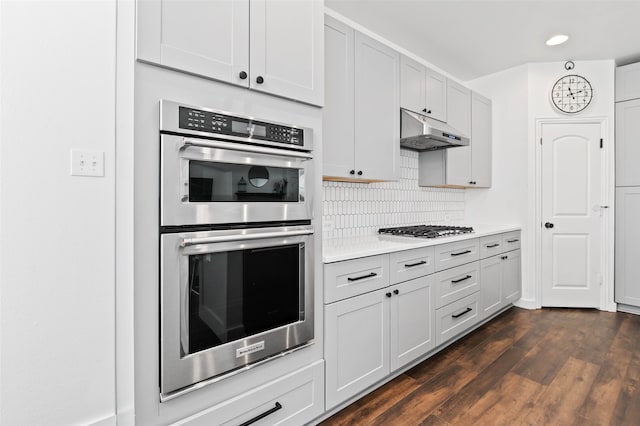 kitchen featuring stainless steel appliances, tasteful backsplash, dark hardwood / wood-style flooring, and white cabinets