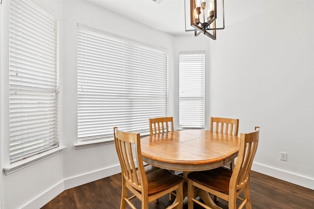 dining room with dark wood-type flooring and a chandelier