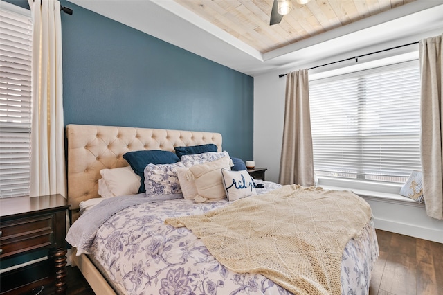 bedroom featuring wood ceiling, dark hardwood / wood-style floors, a raised ceiling, and ceiling fan