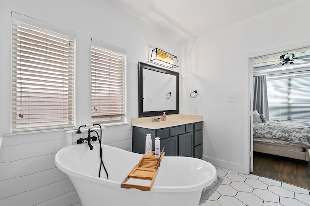 bathroom featuring vanity, a tub, ceiling fan, and a wealth of natural light