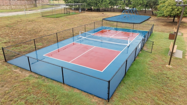 view of tennis court with a yard