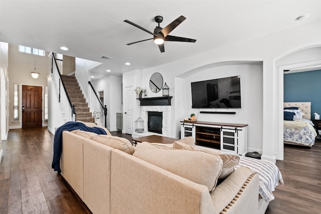 living room featuring ceiling fan, a fireplace, a wealth of natural light, and dark hardwood / wood-style floors