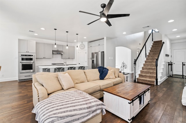 living room with dark hardwood / wood-style floors and ceiling fan