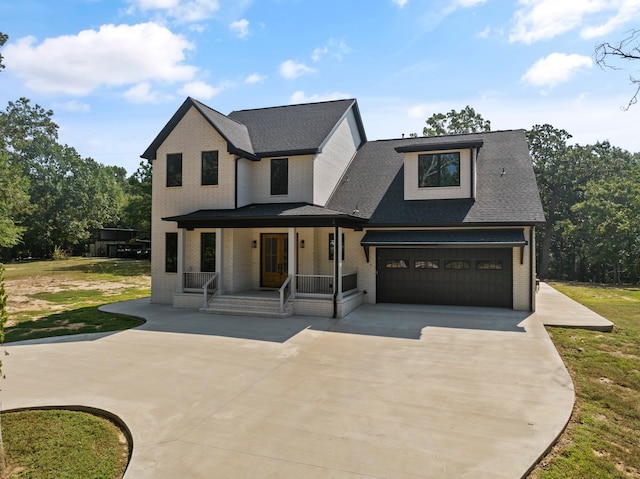 view of front of home featuring a garage, a porch, and a front yard