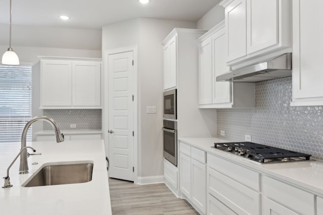 kitchen featuring white cabinetry, appliances with stainless steel finishes, and ventilation hood