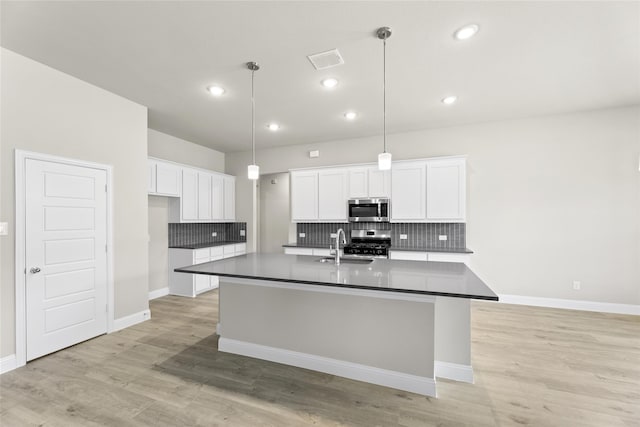 kitchen featuring white cabinetry, light hardwood / wood-style floors, stainless steel appliances, and tasteful backsplash