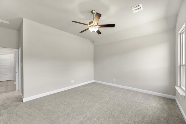 empty room with ceiling fan, lofted ceiling, and light colored carpet