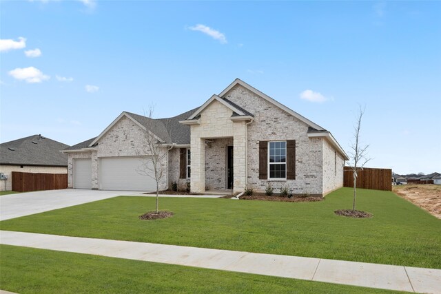 view of front of house featuring a garage and a front lawn