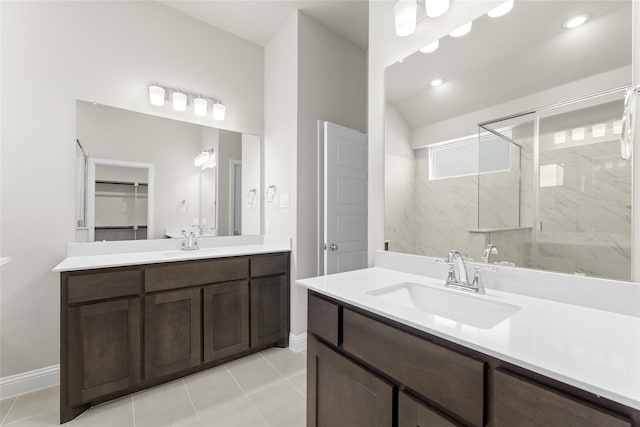 bathroom featuring vanity, a tile shower, and tile patterned flooring