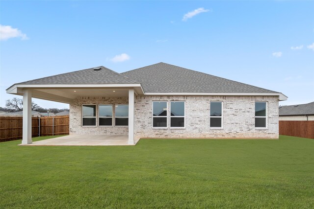 rear view of house featuring a yard and a patio area