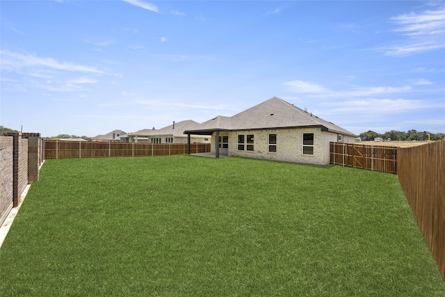 rear view of property with a yard and a patio area