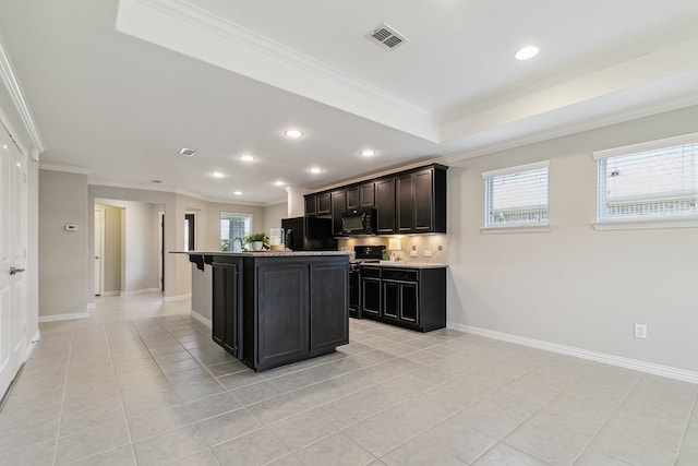 kitchen featuring a center island with sink, backsplash, light tile patterned floors, ornamental molding, and black appliances