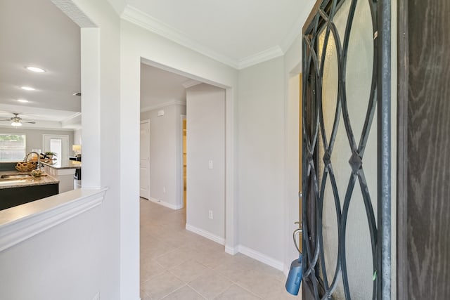 foyer entrance with ornamental molding, sink, light tile patterned flooring, and ceiling fan