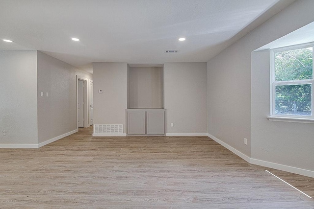 unfurnished room featuring light wood-type flooring, baseboards, and visible vents