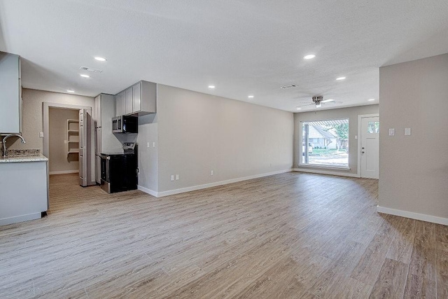 unfurnished living room with recessed lighting, light wood-style flooring, visible vents, and ceiling fan
