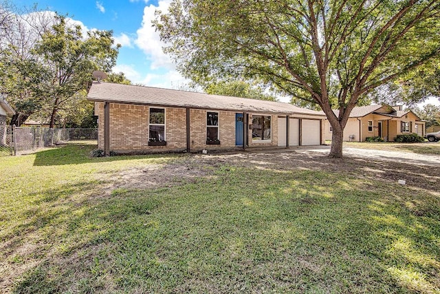 ranch-style house with a front lawn, driveway, an attached garage, fence, and brick siding