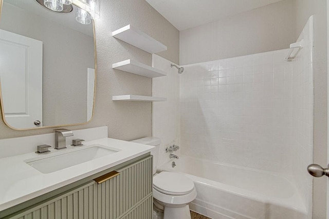 bathroom featuring a textured wall, tub / shower combination, vanity, and toilet