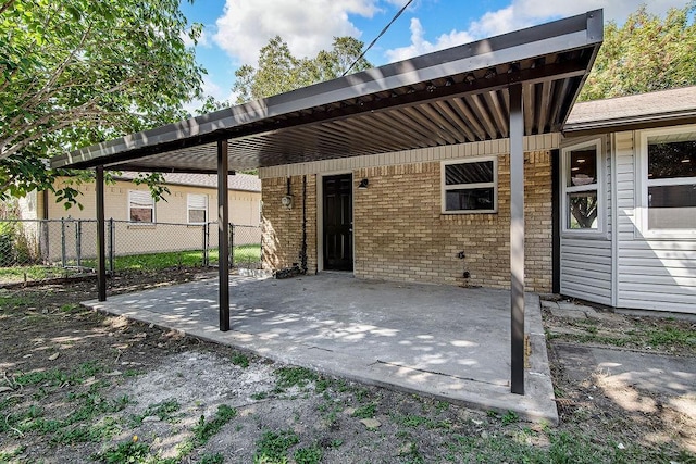 view of patio / terrace with fence and a carport