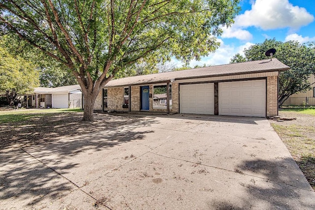 ranch-style home featuring brick siding, an attached garage, and driveway