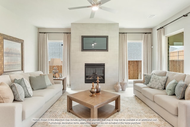 living room with ceiling fan and a tile fireplace