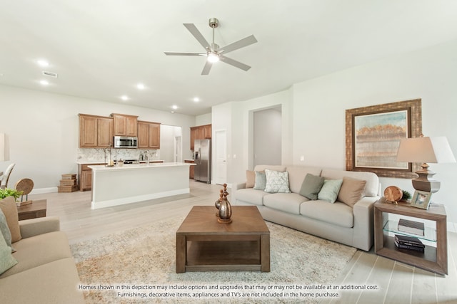 living room featuring ceiling fan and light hardwood / wood-style floors