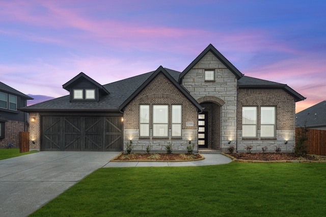 view of front of property with a garage, brick siding, stone siding, driveway, and a front lawn