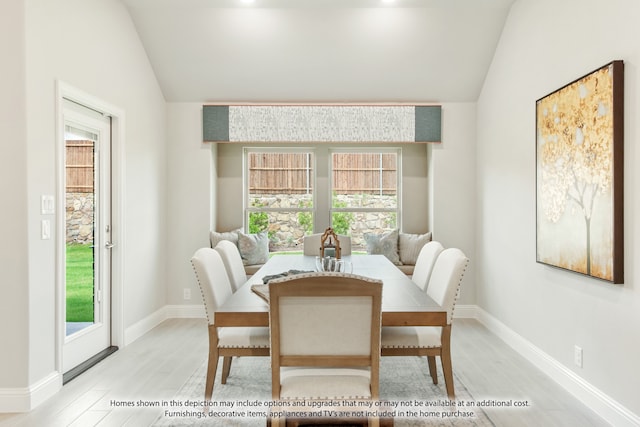 dining area featuring vaulted ceiling and light hardwood / wood-style floors