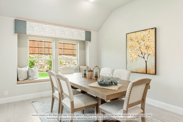 dining space with vaulted ceiling and light wood-type flooring