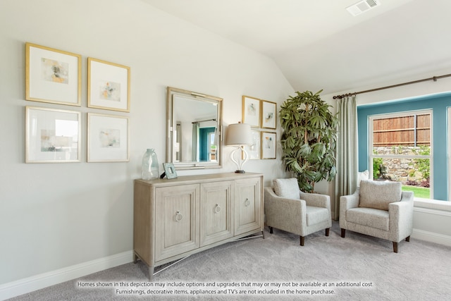 sitting room with lofted ceiling and light colored carpet