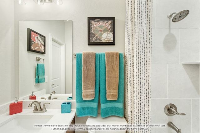 bathroom with vanity and a tile shower