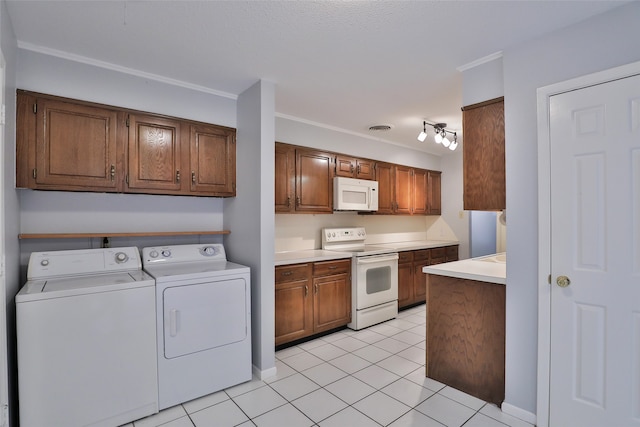 kitchen with crown molding, light tile patterned floors, washer and dryer, and white appliances