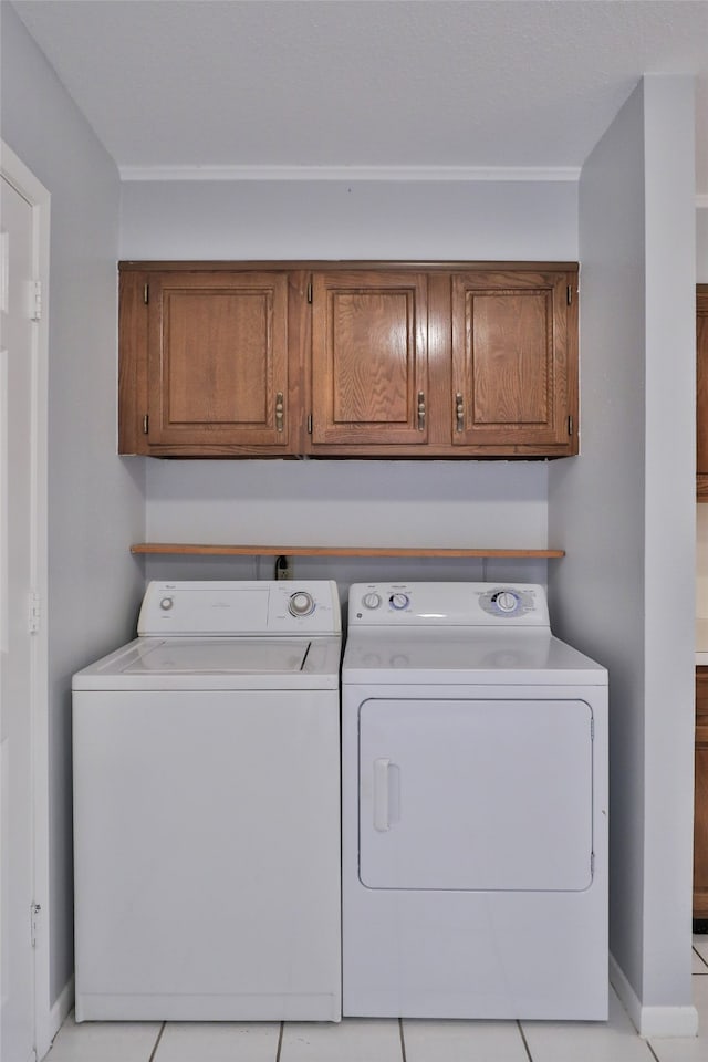 laundry room with light tile patterned flooring, cabinets, and independent washer and dryer