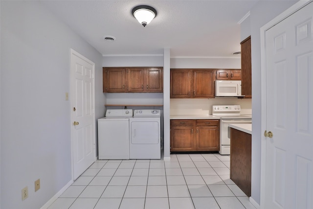 clothes washing area with light tile patterned floors, a textured ceiling, and washer and clothes dryer