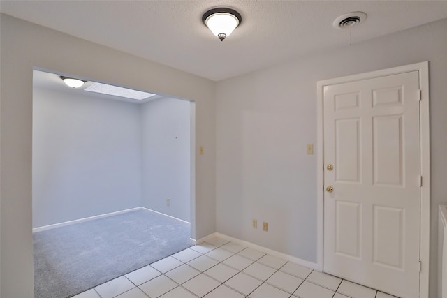 unfurnished room with a textured ceiling and light carpet