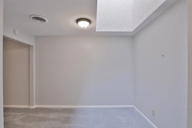 carpeted spare room featuring a textured ceiling