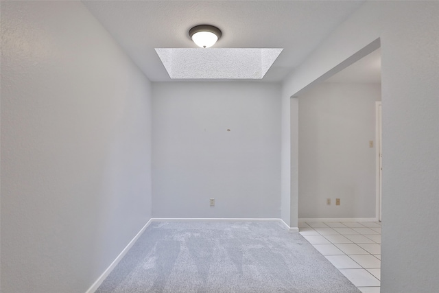 carpeted empty room with a skylight