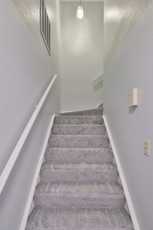 stairs featuring carpet flooring