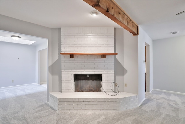 unfurnished living room featuring beam ceiling, light carpet, and a brick fireplace