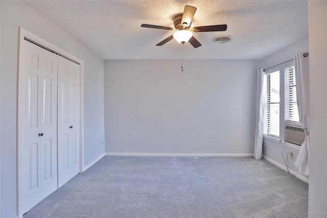 unfurnished bedroom with carpet flooring, a textured ceiling, a closet, and ceiling fan