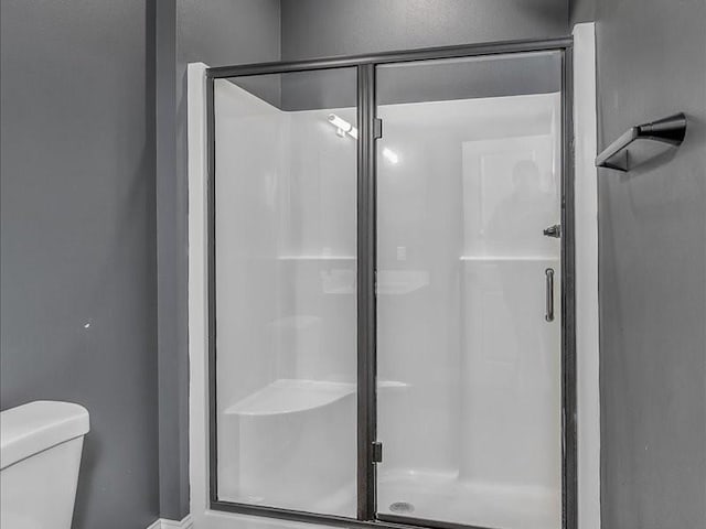 bathroom with toilet and walk in shower