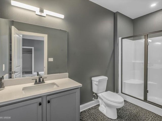 bathroom featuring an enclosed shower, vanity, and toilet