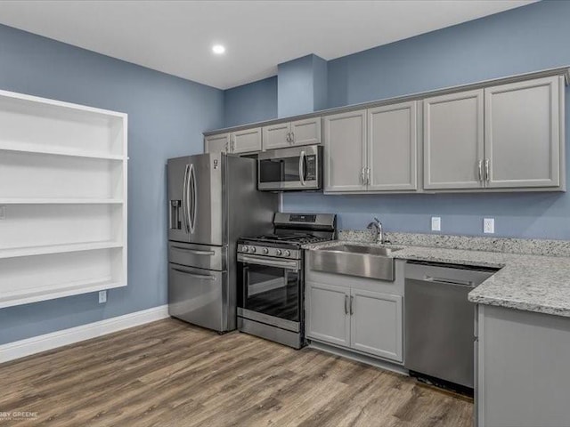 kitchen with gray cabinets, light stone countertops, and appliances with stainless steel finishes