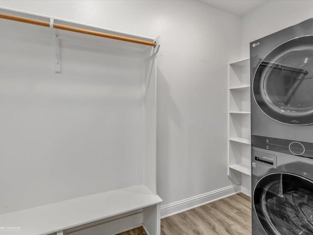 laundry room featuring light hardwood / wood-style flooring and stacked washer and dryer