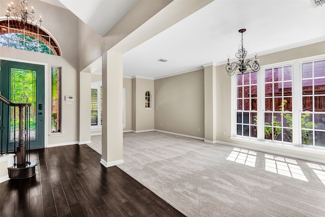 foyer entrance featuring ornamental molding, hardwood / wood-style floors, and an inviting chandelier