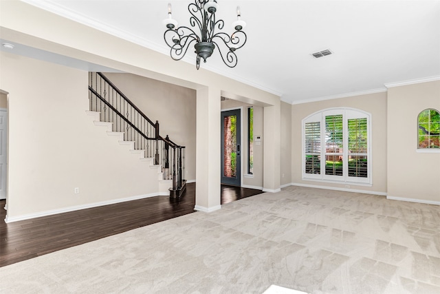 interior space with an inviting chandelier, crown molding, and hardwood / wood-style flooring