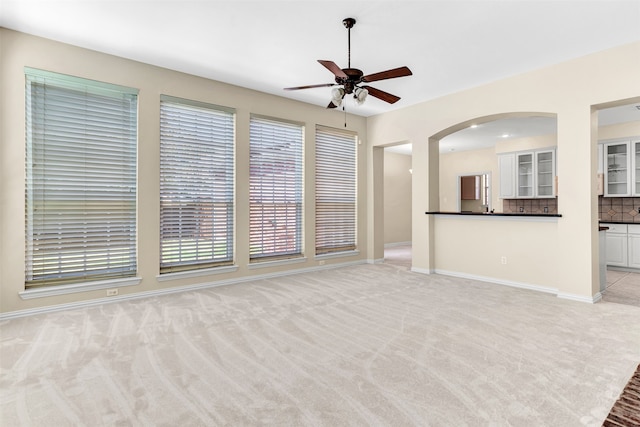 unfurnished living room featuring light carpet and ceiling fan