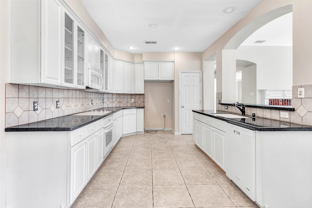 kitchen with light tile patterned flooring, white appliances, white cabinets, and sink