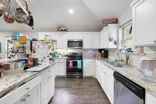 kitchen with sink, dark wood-type flooring, appliances with stainless steel finishes, white cabinetry, and tasteful backsplash