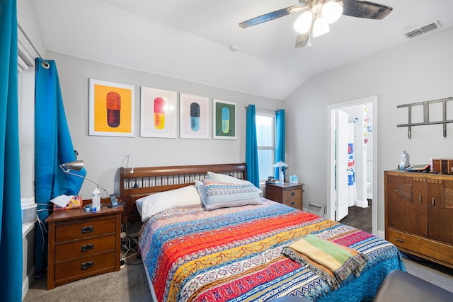 carpeted bedroom with ensuite bath, vaulted ceiling, and ceiling fan